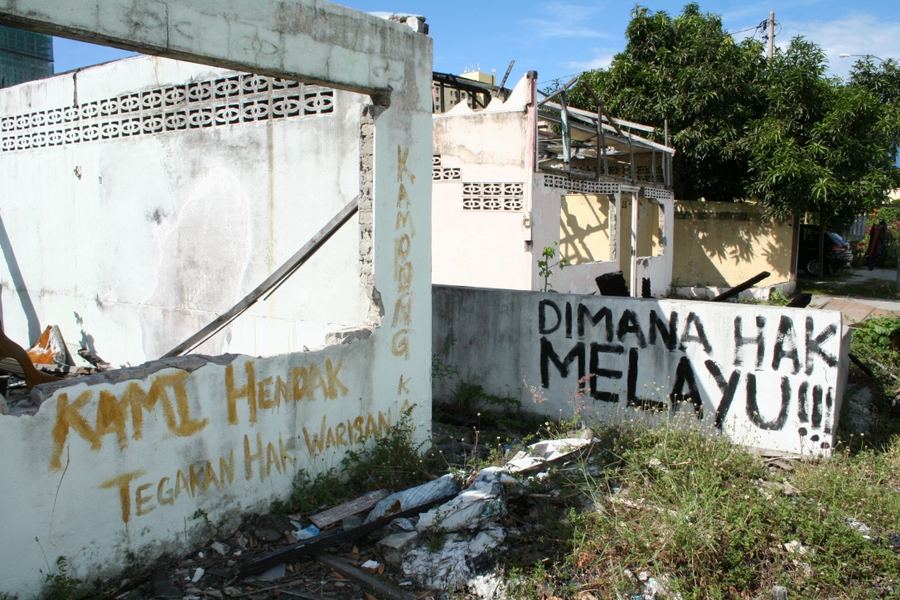 Malay slogans painted on the walls of a half-demolished village house