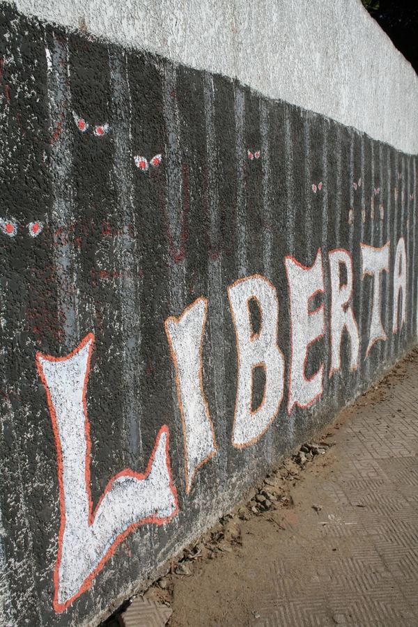 The word Libertad painted in tall white letters along a dark wall