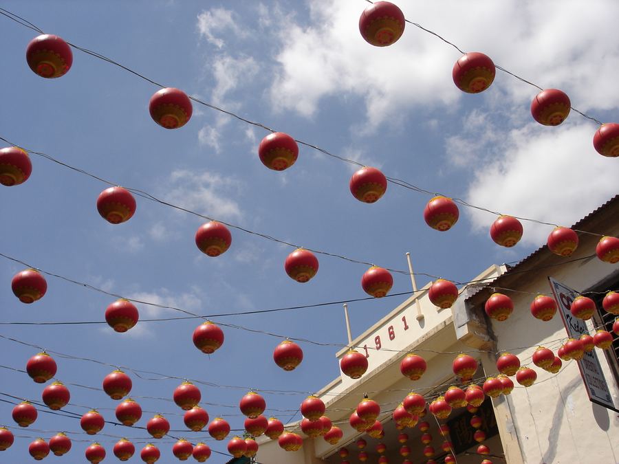 Rows of red paper lanterns strung above a temple roof