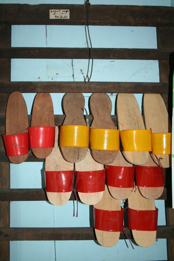 Painted wooden clogs hung in rows on a slatted wall