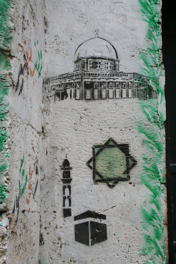 A stencilled Dome of the Rock and Kaaba painted on a whitewashed pillar